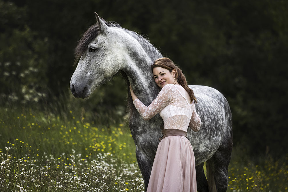 Fotografie mit einem Schimmel und einer Frau im Frühling bei einem Pferdeshooting von Vivien Schust Photography