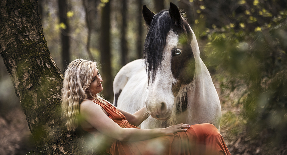 Fotografie eines Schecken/Tinkers und einer Frau im Wald bei einem Pferdeshooting in NRW von Vivien Schust Photography